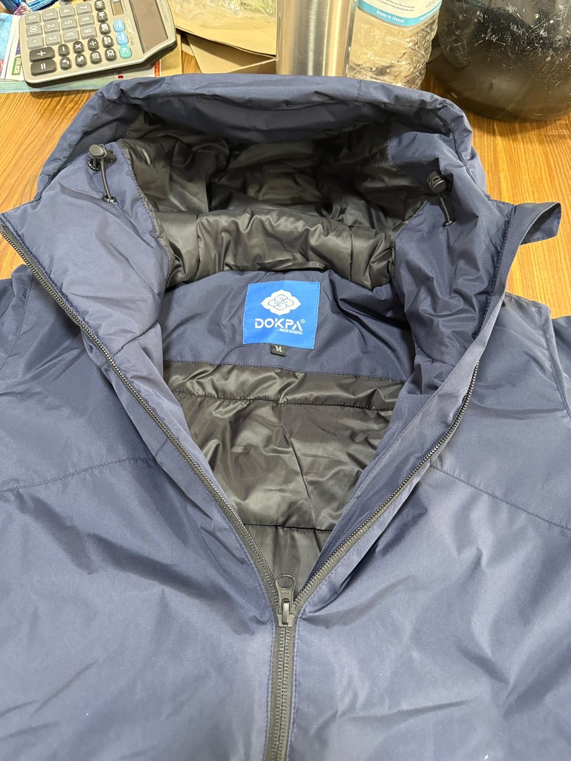 Close view of the blue Dokpa Made in Nepal woven label inside a hood
